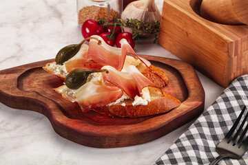 Bruschetta with jamon and caper berries
