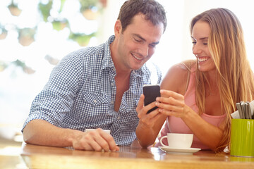 Coffee shop, online and couple with phone in restaurant for talking, bonding and relax in cafe. Happy, love and man and woman with beverage, cappuccino and drink on social media, internet and meme