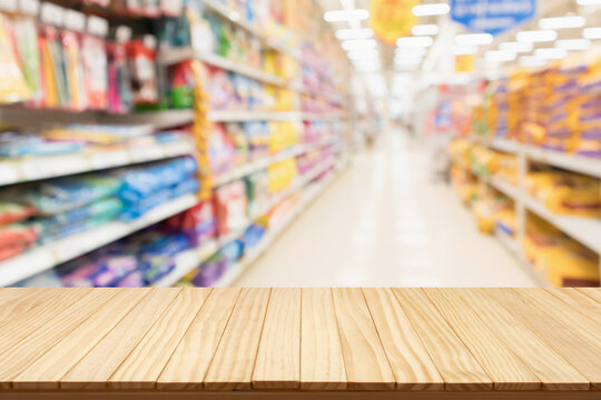 Empty wood table top with spet food shop blurred background