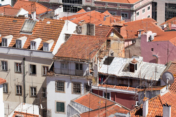 A birds eye view of a few red ceramic tiled rooftops in Lisbon, Portugal.