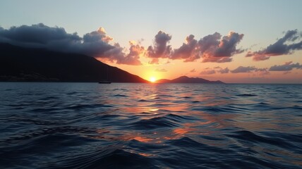 The sun sets over the ocean, casting a golden glow on the water