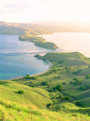 Beautiful sunset view from the cliff with the sea and yellow sky background at Gili Lawa, Komodo National Park, Indonesia. © Balnyes Visuals