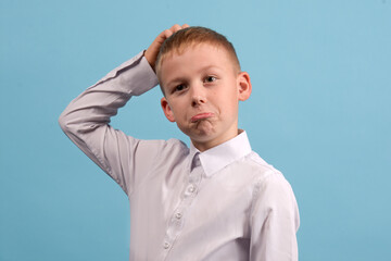 Child 8-9 years old with a thoughtful expression on his face on a blue background