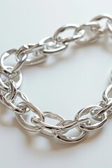Fototapeta premium Silver chain bracelet lying on white background, intricate design with delicate links