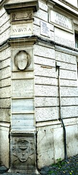 Rome, Italy - November 9, 2024: Marble plaque with historical inscriptions on a building corner at Piazza della Suburra, rione Monti. Eroded reliefs highlight the area&rsquo;s ancient past