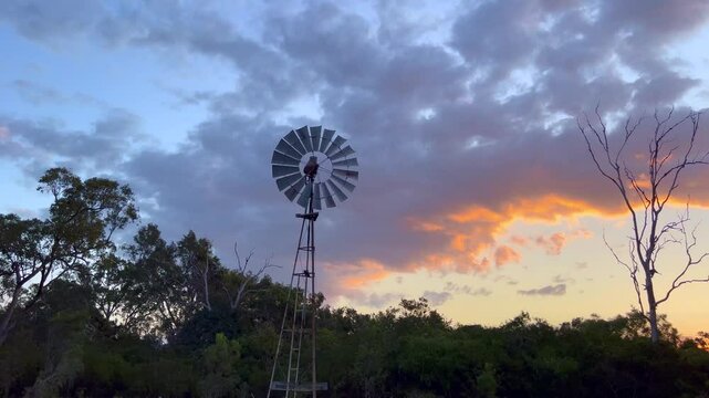 Sunset evening scene over wind pump water pumping in a station farm  in the far north of Queensland, Australia. 