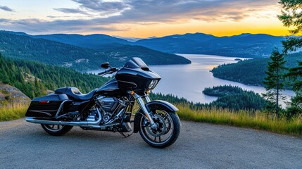 A black touring motorcycle parked at a mountain overlook during sunset, showcasing its sleek design against a rugged landscape