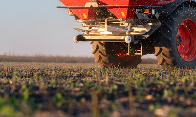 Farmer fertilizing arable land with nitrogen fertilizer
