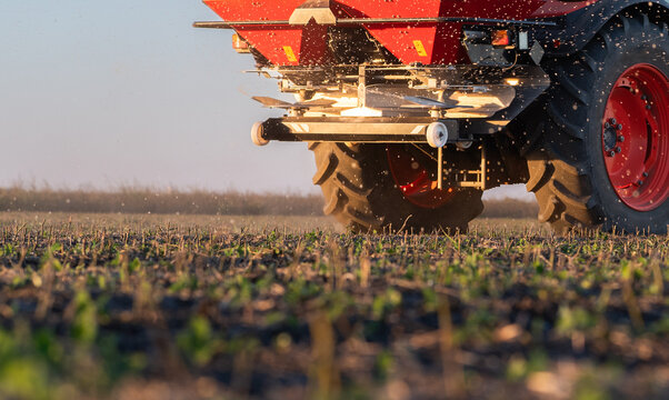 Farmer fertilizing arable land with nitrogen fertilizer