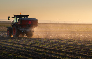 Farmer fertilizing arable land with nitrogen fertilizer