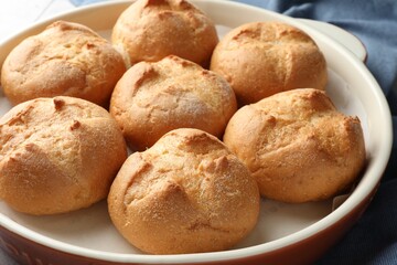 Naklejka premium Baking dish with homemade tasty buns on table, closeup