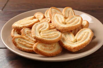 Delicious sweet palmier cookies on wooden table, closeup