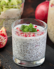Glass of chia seeds and yogurt with pomegranate on table