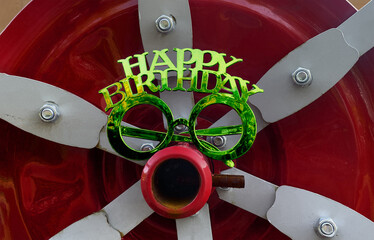 shiny happy birthday glasses on red industrial background