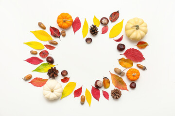 Heart made of autumn leaves, acorns, chestnuts, pine cones and fresh pumpkins on white background