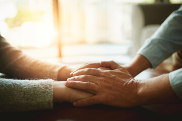People, holding hands and support in home with love, empathy and trust in relationship. Friends, couple and gesture in living room for compassion, hope and healing for emotional wellness with care