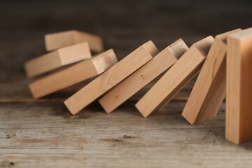 Domino effect. Wooden blocks falling on table, closeup