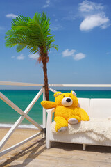 Bear toy on sofa relax on the sea.