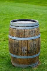 Fototapeta premium Rustic wooden barrel standing on green grass with a natural environment, showcasing the texture and craftsmanship of classic barrel design in outdoor settings