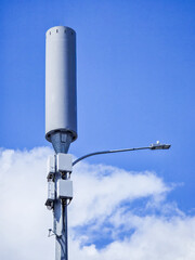 Obraz premium Modern Communication Tower with Blue Sky Background and White Clouds, Illustrating Technology, Connectivity, and Urban Infrastructure in Contemporary Setting