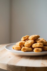 Crispy Fried Chicken Nuggets on a White Plate on a Wooden Table.