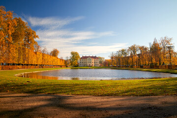 Park with a lordly castle behind a pond in autumn