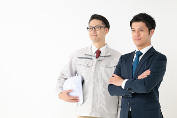 スーツ姿のビジネスマンとヘルメットを持った施工業者