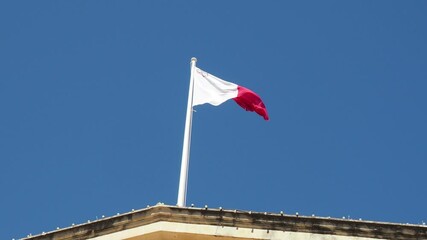 the flag of Malta flying in the wind