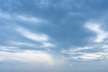 Beautiful fluffy white clouds drift across a clear blue sky