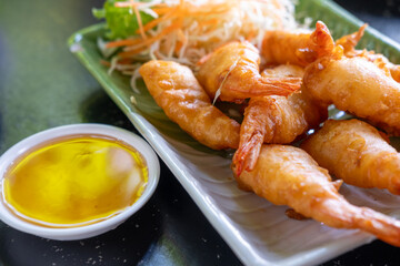 Fried shrimp on plate with sauce, served in a restaurant