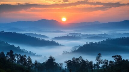 Obraz premium A panoramic view of a sunrise over a misty mountain range, with a deep orange sky and rolling hills.