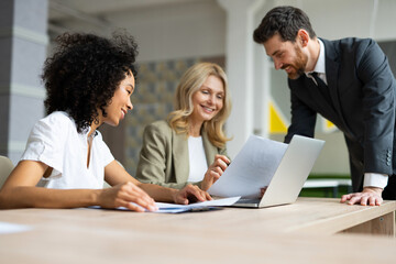 Multiracial group of businesspeople with elegant dress sitting at computer desk in the office - Diverse people   working at laptop online in the meeting room, concepts about business and technology