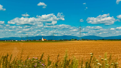 Fototapeta premium Beautiful summer view with a church and the Bavarian Forest in the background near Loh, Stephansposching, Deggendorf, Bavaria, Germany