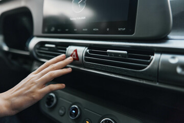 Car air conditioning control a person adjusting an air vent with a red arrow highlighting the center of the air conditioning control panel