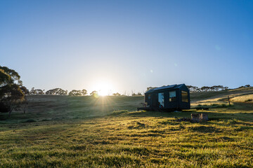 Fototapeta premium Tiny Cabin in early sunrise with sun flare