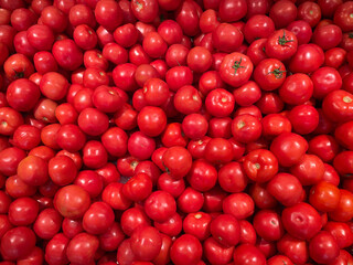 Red bright tomatoes at the market symbolize healthy eating. Organic and fresh tomatoes, just picked and ready to sell or eat. Images of vegetable products