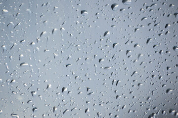 Raindrops on a window indicating gray and rainy day