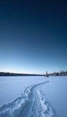 Obraz premium Snowy path winding across a frozen lake under a clear twilight sky