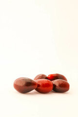 Minimalistic arrangement of fresh cornelian cherries on a white background. A clean and simple composition emphasizing the vibrant red color and smooth texture of the berries