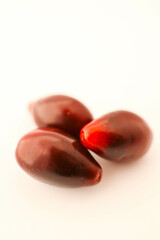 Minimalistic arrangement of fresh cornelian cherries on a white background. A clean and simple composition emphasizing the vibrant red color and smooth texture of the berries