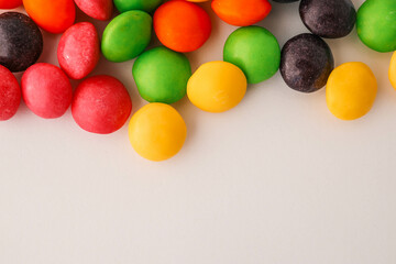 Chocolate round candies scattered on white isolated background