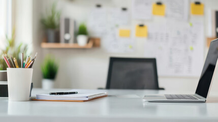 modern home office setup featuring laptop, notebook, and stationery. workspace is bright and organized, with plants and notes on wall, creating productive atmosphere