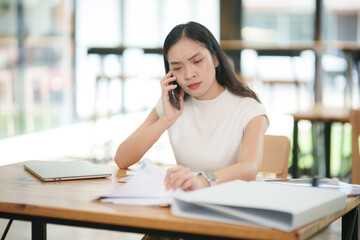 Obraz premium Asian business woman uses a smartphone to talk and give advice to customers.