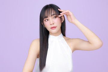 Naklejka premium Beautiful young Asian woman model long hair with natural makeup on face clean skin on isolated violet background. Cute girl portrait, Facial treatment, Body care, Beauty and Spa.
