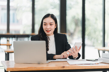 professional woman engages in video call while using smartphone, showcasing modern workspace. Her focused expression reflects determination and productivity