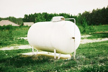 Large white propane gas tank providing clean energy to a rural home