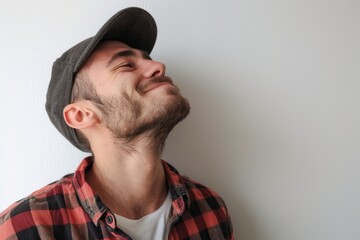 Obraz premium A man dressed in casual attire, wearing a hat and a plaid shirt