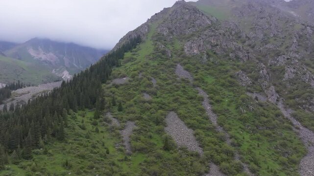 Ala Archa National Park at summer day in Kyrgyzstan, aerial view with truck to the left camera movement.