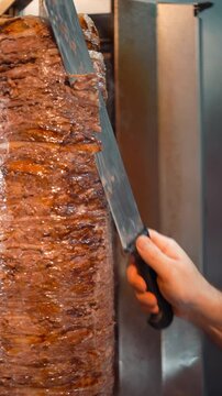 Close Up of Doner, Preparation of a Delicious Turkish Classic. Chef Slicing Traditional Doner Kebab Close-Up