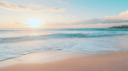 Obraz premium Sunrise over the ocean with waves crashing on a sandy beach.